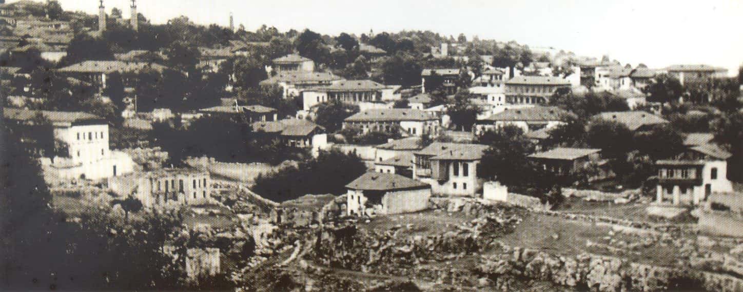 Panoramic view of a hillside town of stone houses and church towers among trees