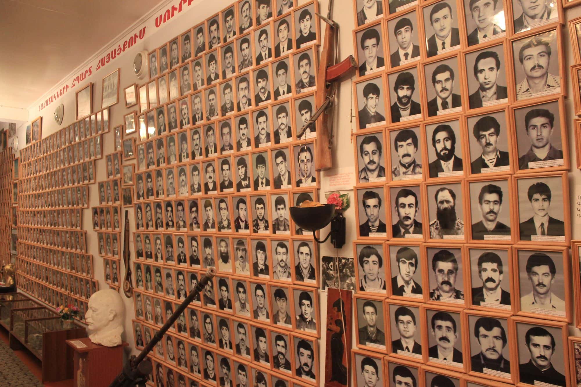 Interior wall of a museum in Stepanakert covered with framed portrait photographs of soldiers killed in the war