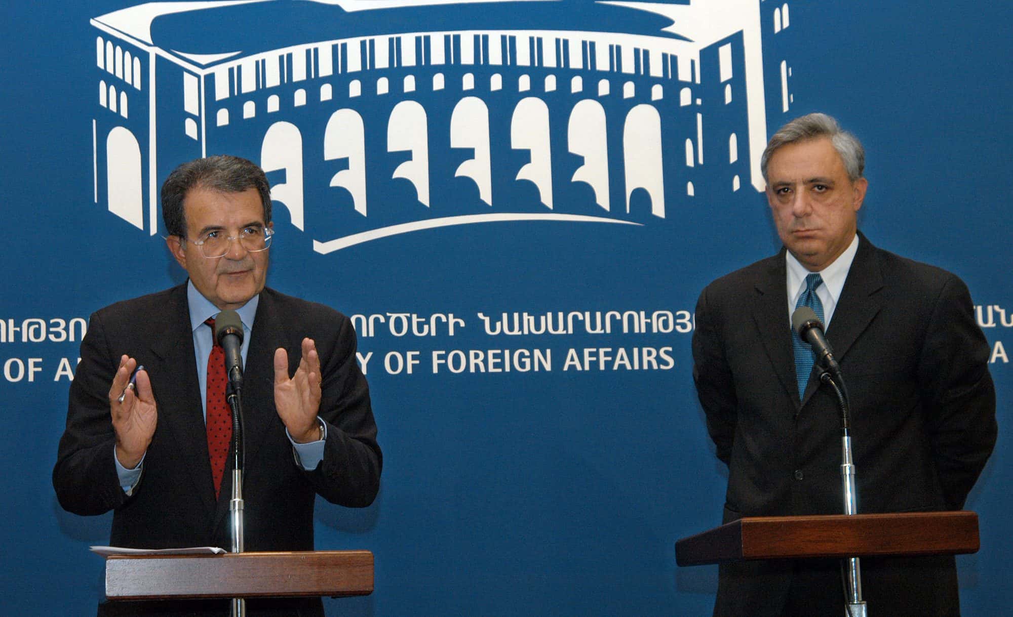 Two men in suits seated together at a formal meeting, photographed in 2004