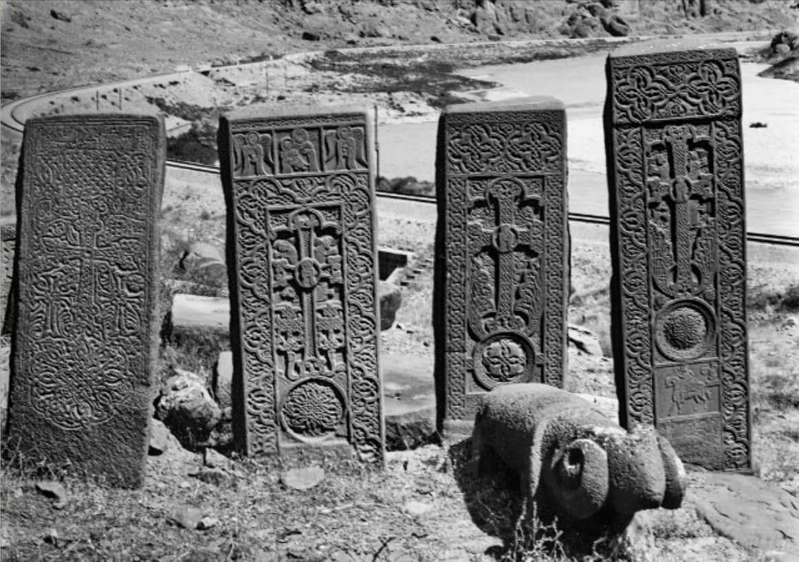 Dozens of carved upright cross stones crowded across a sloping cemetery field