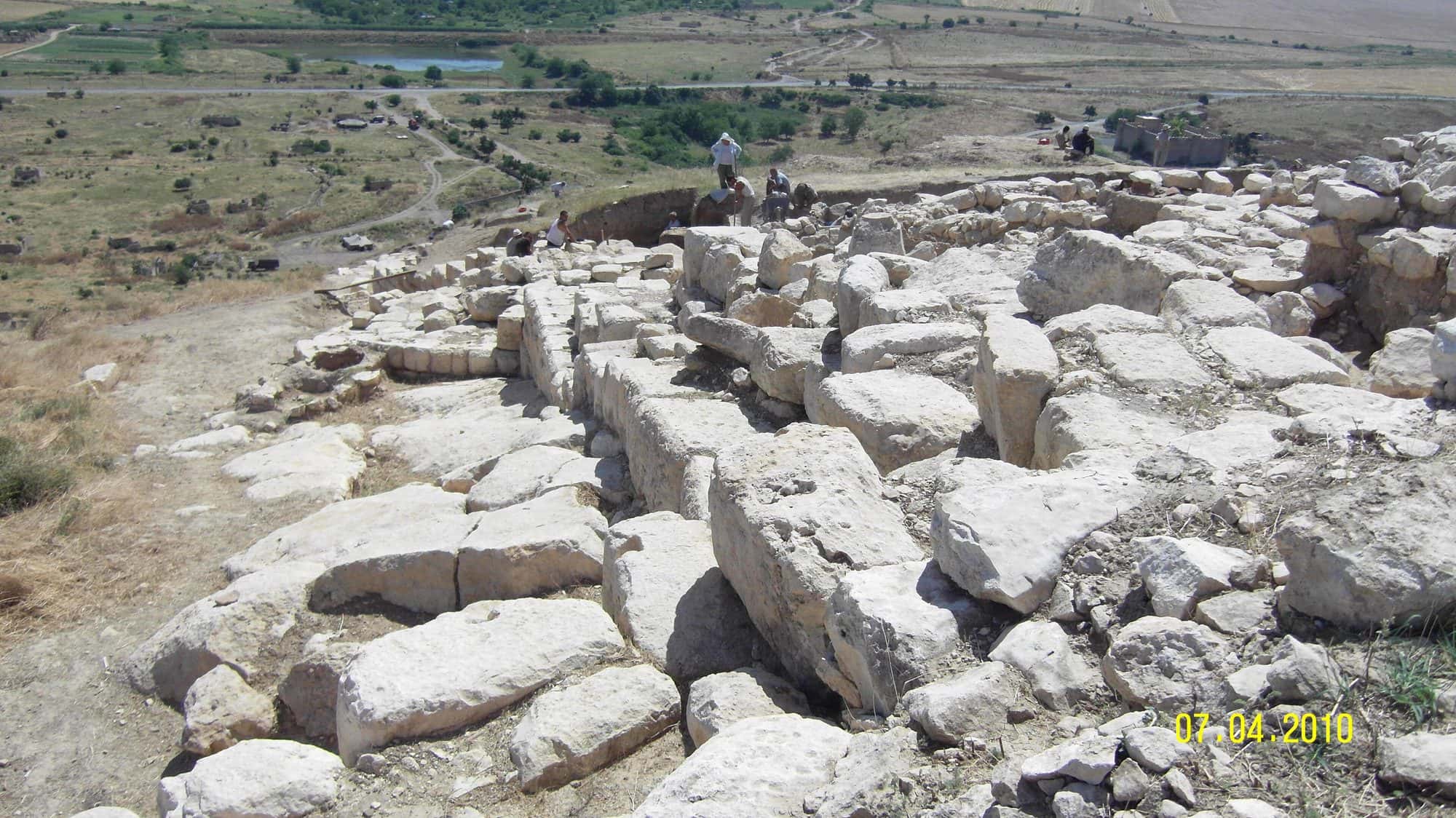 Stone walls and towers of an ancient citadel standing on a dry hillside