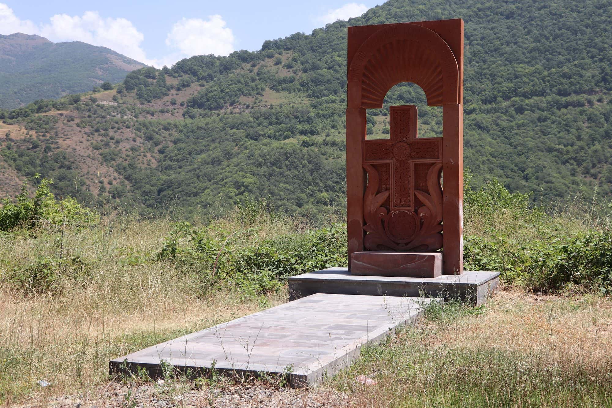 Carved stone cross memorial standing outdoors, dedicated to soldiers killed in April 2016