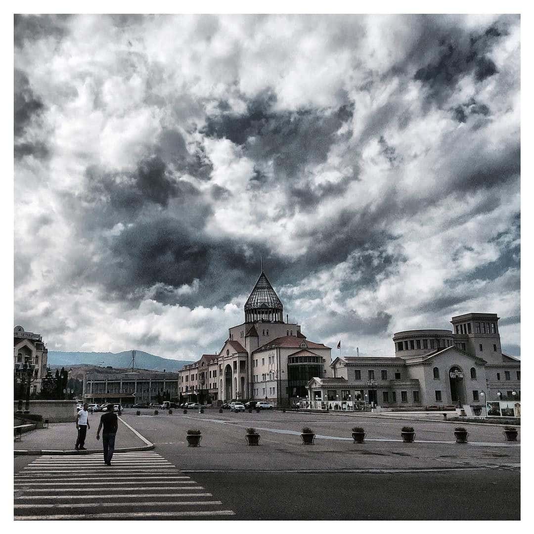 Open paved civic square in Stepanakert with government buildings and street lamps around it