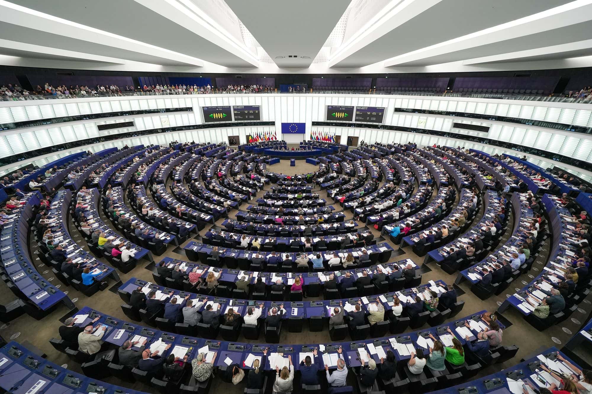 Wide view of the European Parliament chamber with members seated in curved rows