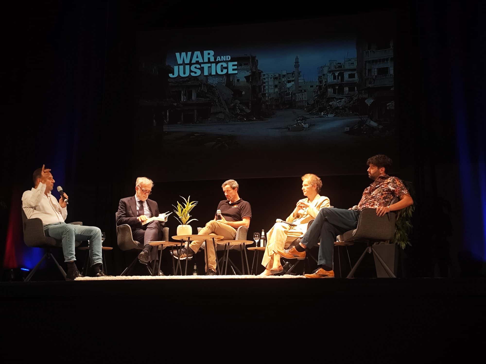 Luis Moreno Ocampo seated speaking during a public panel discussion