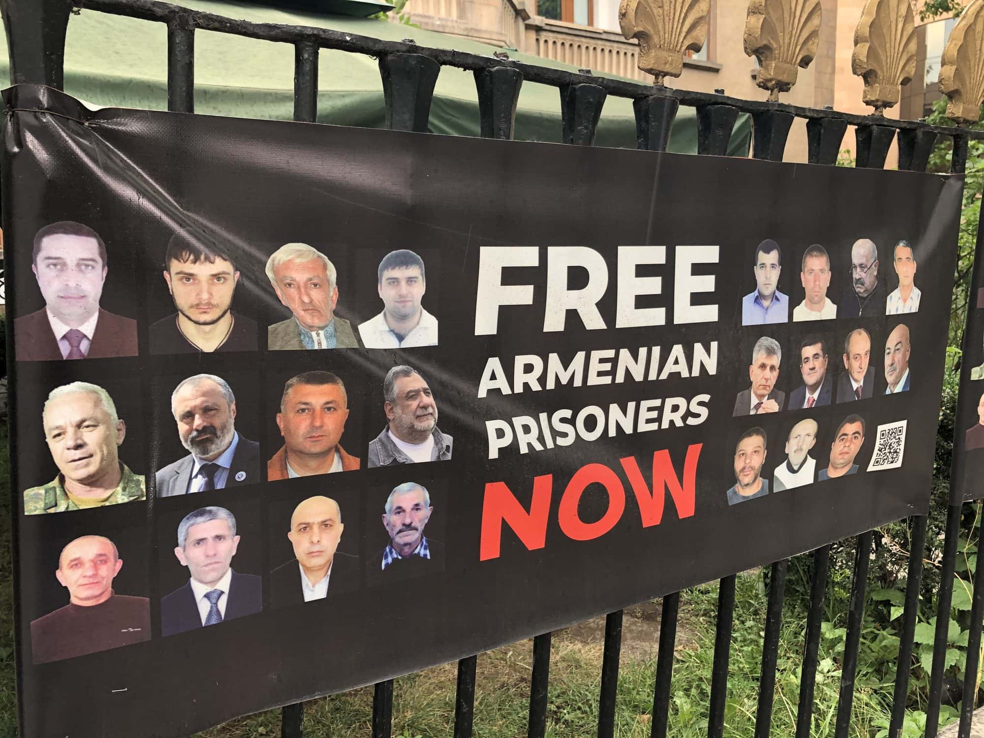 Printed campaign sign in English calling for the release of Armenian prisoners and officials